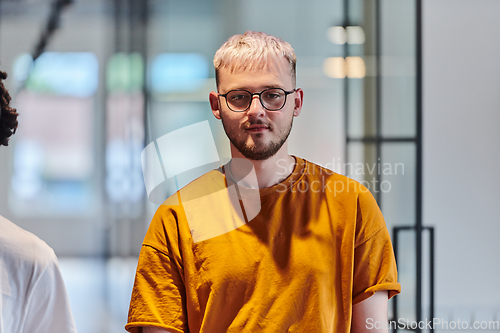 Image of A modern portrait captures a blue-haired businessman wearing glasses, exuding creativity and professionalism, within the ambiance of a startup coworking office