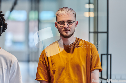 Image of A modern portrait captures a blue-haired businessman wearing glasses, exuding creativity and professionalism, within the ambiance of a startup coworking office