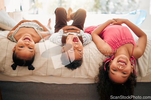 Image of Silly kids playing upside down on bed enjoy and having fun together in parents bedroom. Happy children or siblings bonding and enjoying childhood together at cozy, warm and comfortable family home