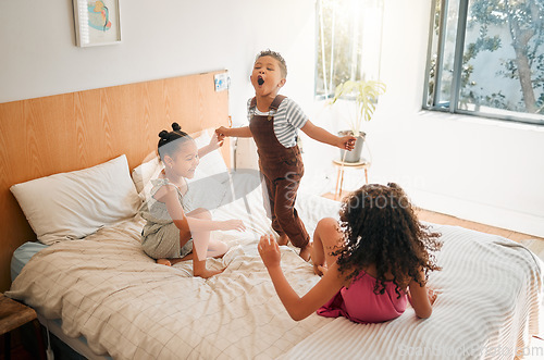 Image of Children, fun and energy by playing siblings jumping, bonding and enjoying a game on bed at home together. Kids laughing and having fun, sharing playful moments of childhood, celebrate free weekend