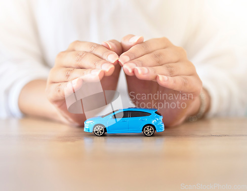 Image of Care insurance, security and safety with the hands of a broker covering model or toy transport on a table in a corporate office. Finance, accountant and travel with an employee offering vehicle cover