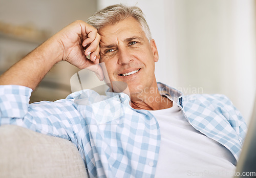 Image of Handsome mature man relaxing on a sofa, casual, carefree and happy at home. Senior male enjoying the pleasure of retired life, satisfied and stressless. Older guy thinking, smiling and daydreaming