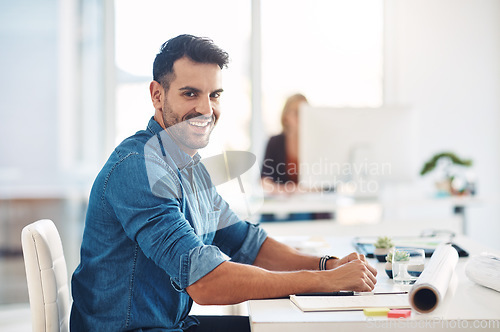 Image of Happy creative businessman working at his desk, doing admin and taking notes while in an office at work. Portrait of a cheerful, smiling and professional male with a positive attitude and expression