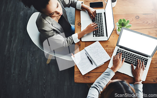 Image of Above view of professional employees talking and working together on a strategy project on their laptop in a modern office. Corporate colleagues sitting in a formal business meeting, discussing plans