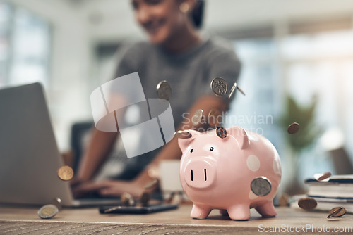 Image of Financial strategy, investment or finance saving with a piggybank and coins falling out on a desk. Bank cash and money or digital budget growth of a person looking at online banking in the background