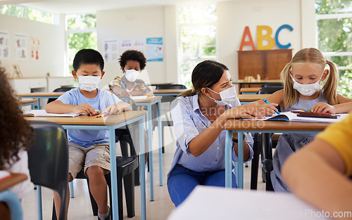 Image of Covid learning with teacher and school students having lesson, study and education in class during pandemic. Educator helping, showing and talking to young kindergarten, preschool and elementary kids