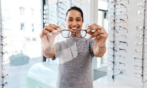 Image of Female holding pair of trendy new glasses, stylish spectacles and prescription lenses at an optometrist. Portrait of a customer choosing, buying and shopping for frames for better vision and eyesight