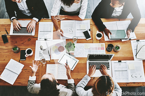 Image of Overhead of colleagues having a marketing meeting in modern office. Above a busy workplace, coworkers brainstorm and develop strategies for a startup business, unity, planning and innovation at work