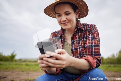 Image of Farmer texting or scrolling on social media on a phone for online sustainability tips relaxing on an organic farm. Nature activist browsing and searching the internet for sustainable farming ideas