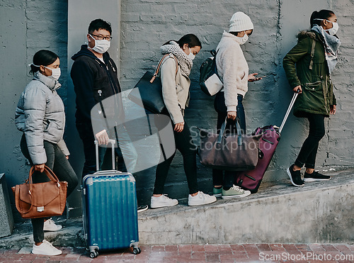 Image of Traveling people wearing covid face mask and suitcases waiting in line or queue at the airport departure or arrival during a global coronavirus pandemic. Immigration of foreign tourists in quarantine