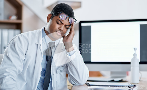 Image of Doctor suffering from headache, stress and pain while working in a hospital. Young, tired health care professional worker feeling the pressure of a heavy workload during corona virus pandemic