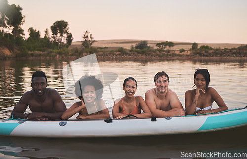 Image of Diverse group of friends having fun while swimming at a lake in summer with a floating kayak boat. Happy, young and multiracial people on vacation enjoying nature and water on a canoe at sunset.