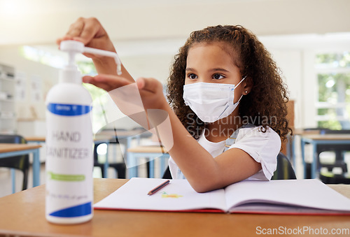 Image of Sanitizer, covid and clean young girl at elementary school wearing a mask in a classroom. A child following protective covid19 regulations by cleaning her hands to prevent infection