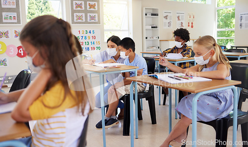 Image of ... Learning, covid teaching and studying young students sitting in a school classroom indoors. Education of youth, children and kids with masks looking and working on class work in a pandemic.