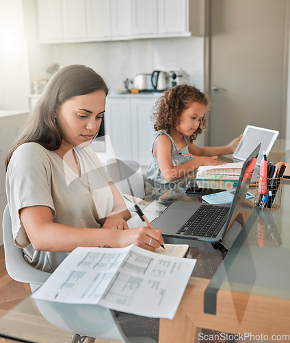 Image of Mother and daughter being productive with remote work and homework, multitasking at a kitchen table at home. Parent and child serious while paying bills and watching an online education programme