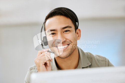 Image of Smiling, friendly call center agent with headset for online consulting in an IT tech agency. Face of male ecommerce support professional offering virtual assistance to web user or contact us hotline