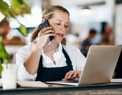 Image of Coffee shop owner on a phone call while working online on her laptop inside a local cafe store. Contact us, learn about us and talk to our baristas, managers and small startup business entrepreneurs