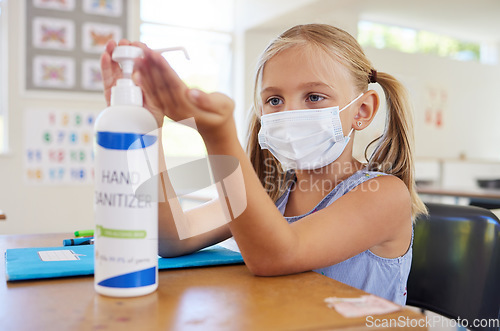 Image of Little student sanitizing hand to protect from covid, wearing a mask and following new hygiene safety routine. Kindergarten or preschool female learner protecting herself from corona virus flu