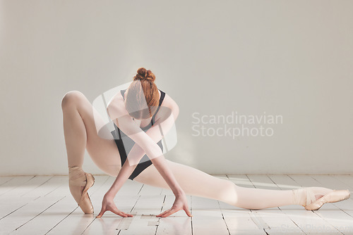 Image of Female ballet dancer in professional ballerina dance posture, dancing or difficult performance in studio rehearsal. Performing artist in point shoes and flexible legs, arms or art technique on floor