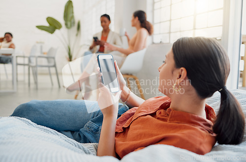 Image of Creative businesswoman, designer or digital marketing agency employee on her phone browsing and searching on a break. Female worker reading or looking for ideas for social media trends on bean bag.