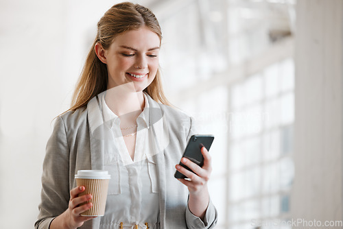 Image of Phone, coffee and online of a young employee texting on smartphone in a corporate office. Happy, smile and mobile woman on the internet at work networking, news and social media at the office.