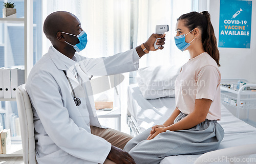 Image of Temperature, thermometer and covid routine with doctor, medical professional and healthcare worker in clinic, hospital or wellness center. Woman or patient with mask checking fever to prevent disease