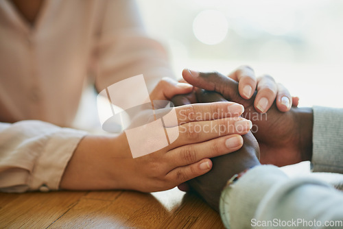 Image of Comfort, kindness and forgiveness with a biracial couple holding hands, united in support in a crisis. Caring wife showing love to her depressed husband with a gentle gesture of affection