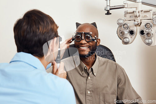 Image of Optical exam, optician or eye doctor at work testing vision or sight of patient at optometrist. Happy, smiling young man checking his eyes for glasses or treatment at an ophthalmologist in a clinic.