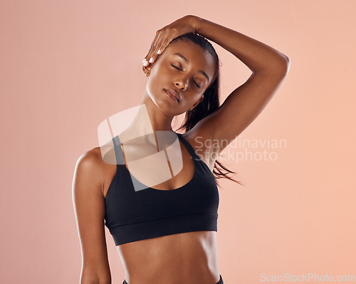 Image of Slim, fit and stretching exercise of a woman feeling confident about her body and health against a pink studio background. Sporty and active woman staying healthy and in shape during a workout