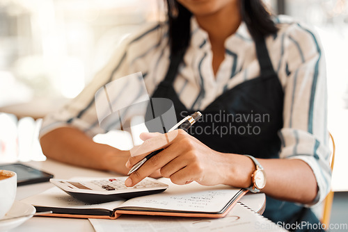 Image of Hands of business owner taking orders, calculating profit and working on budget for startup while sitting at a table at work. Closeup of a female employee doing finance job, sorting bill and writing