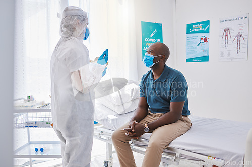 Image of Doctor consulting a patient with covid, sickness or disease in a healthcare facility or clinic. Medical professional in a hazmat suit writing a patients symptoms on a chart in a hospital check up