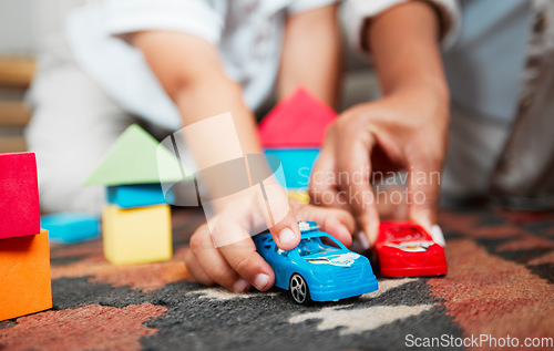 Image of Closeup hands playing with fun toys, cars and building blocks in a home living room. Parent bonding, having fun and enjoying family time with a playful, small and little child during childhood fun