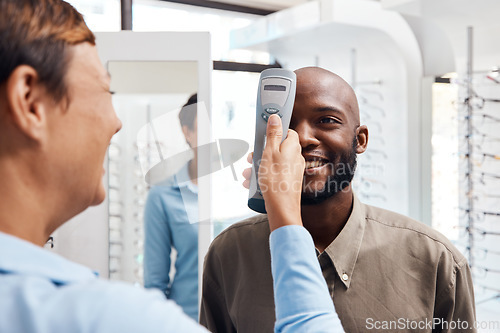 Image of Eye exam, eyewear and an optometrist checking happy young male eyes with optic medical equipment. African man getting his eyesight checked by a tonometer. Smiling guy getting new spectacles.