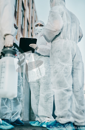 Image of Healthcare workers outside in protective gear during an outbreak in the city. A group of scientists wearing hazmat suits, cleaning urban areas. Safety staff in coveralls due to covid health risks.