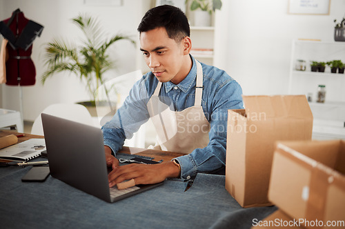 Image of Creative startup, online order and designer in his fashion studio workshop on a laptop. Internet as a marketplace for ecommerce to advertise and sell products before packaging and delivery by courier