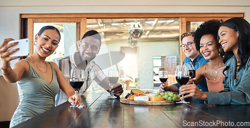 Image of Diverse friends taking selfie on a phone while bonding, drinking wine and eating together at a restaurant. Fun group enjoying gathering, reunion, laughing, talking and celebrating friendship