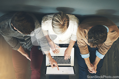 Image of A group of planning, researching and professional business people working together on a laptop while sitting on the floor top view. A team of designers searching the web or completing a project