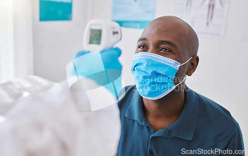 Image of Man doing covid temperature check with medical doctor, checking for fever during checkup and wearing a mask to protect from virus. Expert, professional or healthcare worker consulting and doing exam