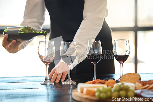 Image of Luxury, fine dining and hospitality with a waiter pouring red wine at a restaurant. Preparing for a wine tasting with a professional sommelier, good service with quality drink by a male winemaker