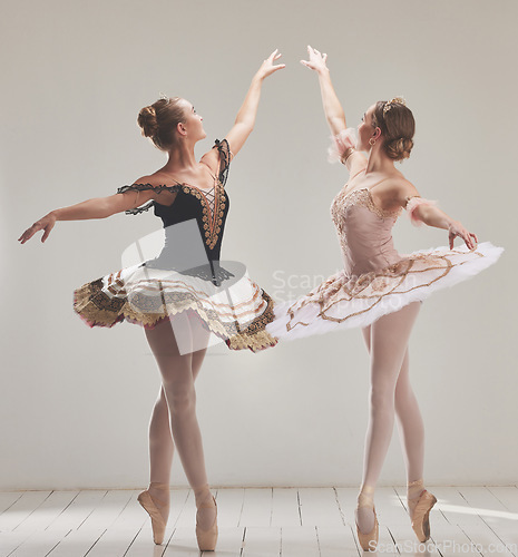 Image of Ballerina, ballet dancer and creative performance, training rehearsal and choreography with en pointe technique on toes in dance studio. Graceful, elegant and beautiful women dancing in tutu costume