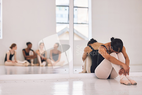 Image of Bullying, stress or sad ballerina in training with ballet dancers, artists or professional studio performers. Upset, unhappy or anxious girl with bad mental health from bullying in theater rehearsal