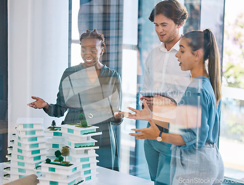 Image of Team of architects, designers or engineers planning and talking about a building design or prototype in a meeting. Group of city planners having a discussion in boardroom and are happy with the model