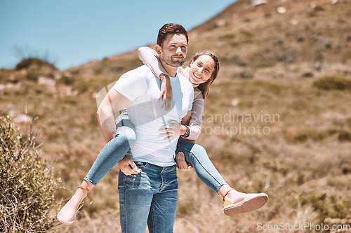 Image of Happy and in love couple having fun in nature and enjoying quality time together. Cute and relax boyfriend piggyback or carrying girlfriend with a smile on a bonding and romantic countryside date