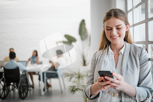 Image of Phone, networking and communication with a business woman on social media in an office for a meeting with a team in the background. Advertising, marketing and teamwork with a worker typing a message