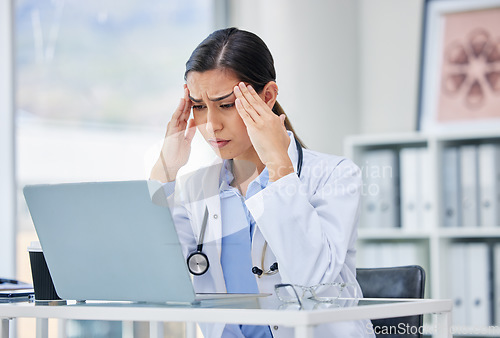 Image of Stress or burnout with doctor thinking and working on laptop in hospital consulting room or office. Medical healthcare worker or specialist surgeon with anxiety headache from mental health issues