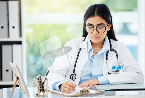 Image of Doctor, insurance and medical of a woman filling out patient history for diagnosis at the hospital. Healthcare worker or nurse writing on paper with clipboard for health and wellness at the office.