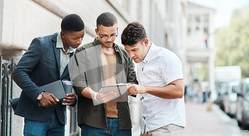 Image of Team of creative designers checking a website for ux and ui while working for a startup. Group of young guys looking at a homepage on a tablet while developing a new business strategy or mission