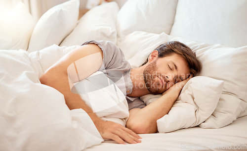 Image of Relax, sleep and peace of a tired man sleeping in a bedroom bed at home. Dreaming, relaxing and resting calm attractive person with closed eyes on a pillow at his house in the morning taking a nap