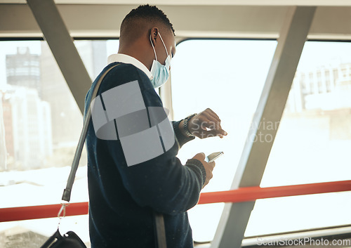 Image of Travel businessman with covid face mask on his way to corporate or business opportunity in the city. Young black business man checking time, running late due to covid 19 airport delay and compliance