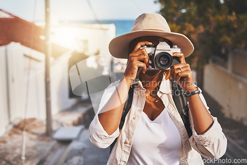 Image of Photographer, travel or tourist taking pictures or photos outdoors in a new town. Traveler using a camera while on a trip at a vacation or holiday location on a sunny day doing a photoshoot